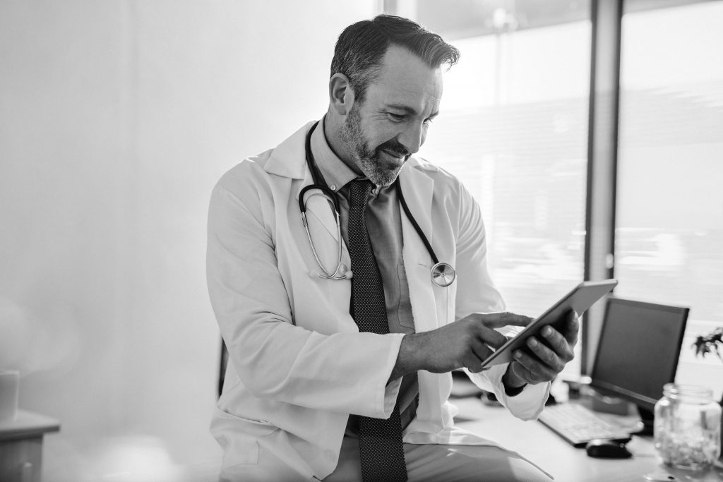 Doctor using digital tablet at his clinic